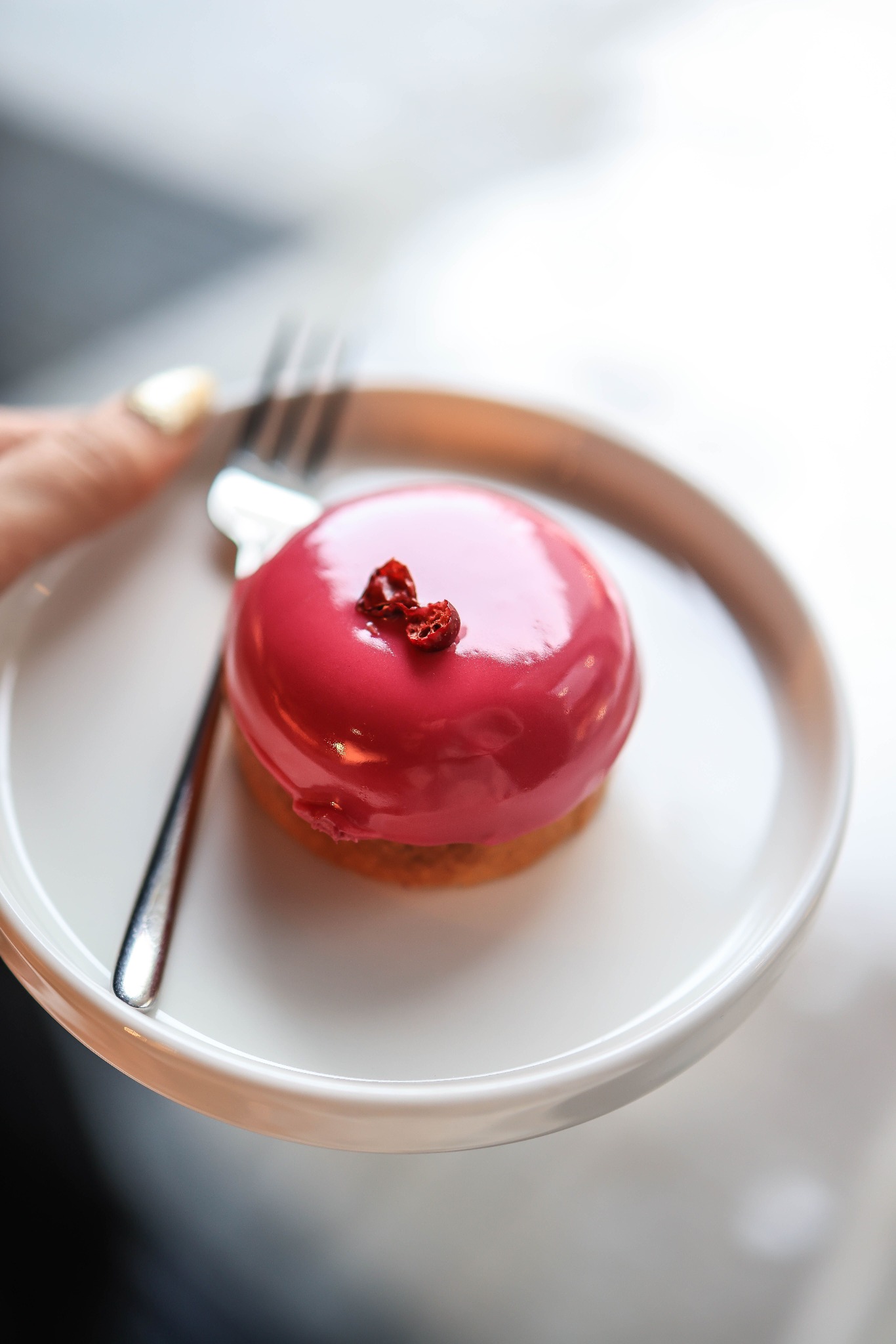 Glossy berry-red pastry on a pale plate